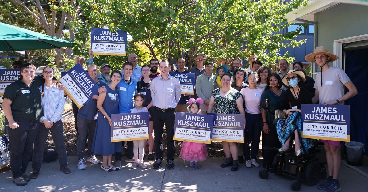 Supporters holding James Kuszmaul yard signs at the campaign kickoff.